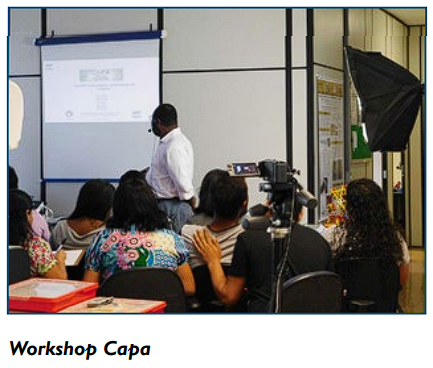 Foto de um workshop com vários participantes assistindo uma apresentação