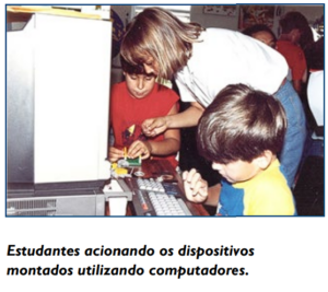 Estudantes acionando os dispositivos montados utilizando computadores.