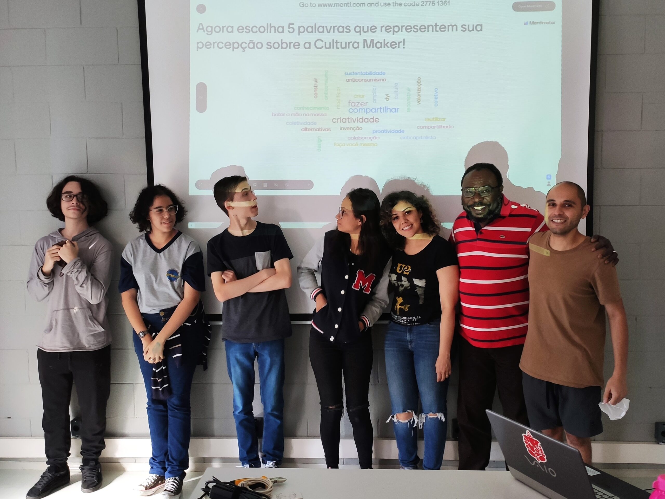 Percepções sobre Cultura Maker: Foto com alunos do PIBIC-Ensino Médio, Bolsistas BAS, mestranda e o pesquisador-orientador com projeção da nuvem de palavras ao fundo (foto 2)